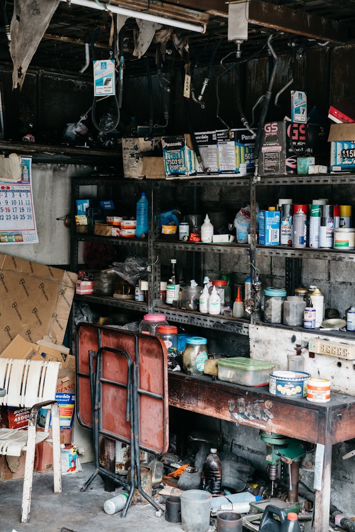 Services A messy garage interior showcasing shelves filled with various tools and supplies.