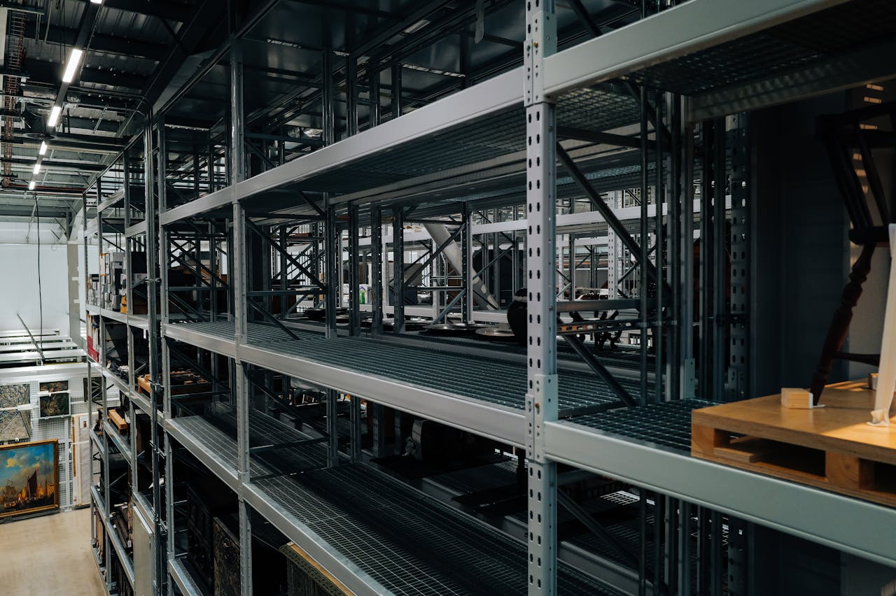 Services Empty metal storage racks in a spacious industrial warehouse setting.